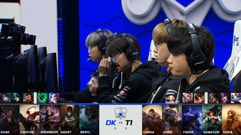 A screenshot from the 2021 World Championship Main Event Semifinals broadcast, showing the Game One champion drafts between DAMWON KIA and T1 with a shot of the T1 LoL roster on stage above.